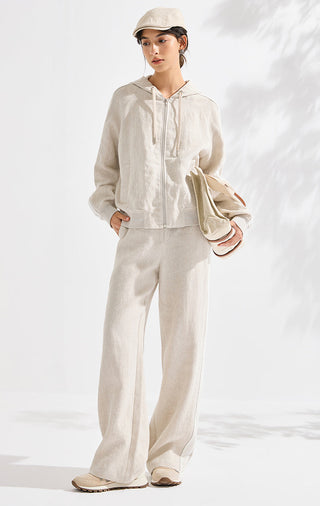 Beige linen hooded relaxed jacket with drawstring hood, styled with light trousers