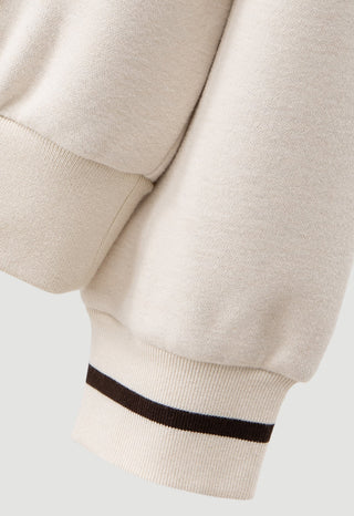 Cream wool-blend pullover sleeve with ribbed cuff and dark striped hem band