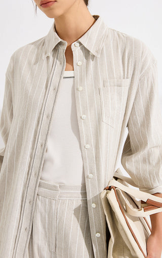 Beige striped shirt close-up: buttoned collar, chest pocket, and white button placket