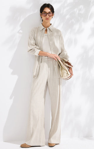 Beige vertical striped relaxed shirt with collar and button-front, styled with wide-leg pants