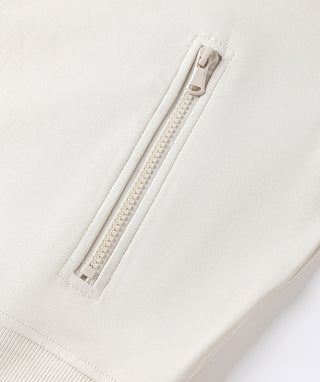 Oatmeal front zipper close-up with metal pull and stitched placket
