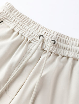 Close-up: cream elastic waistband with drawstring and metal eyelets on relaxed pants