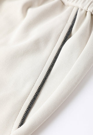 Close-up of cream side pocket with visible zipper trim on relaxed wide-leg pants