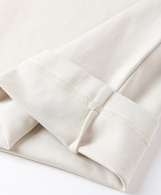 Relaxed wide-leg pant hem in cream fabric with stitched cuff and clean finish