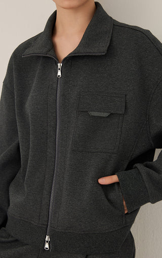 Dark gray zip jacket close-up: metal zipper, stand collar, chest pocket