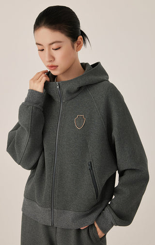 Dark gray cotton zip-up hoodie with hood and beaded shield crest badge; front zip & pockets.