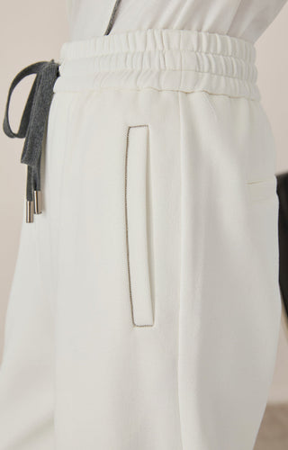 White elastic-waist lounge pants with metal drawstring ends and vertical back pocket detail