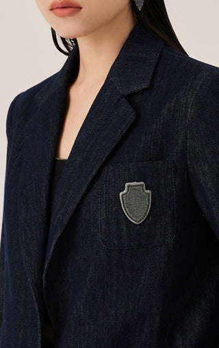 Close-up dark blue blazer showing crest emblem patch on the chest pocket