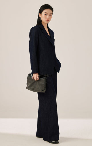 Dark blue tailored blazer front with crest patch, worn with matching trousers