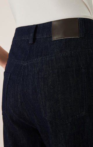Close-up of black tailored pants: button waistband, zip fly, and welt pocket