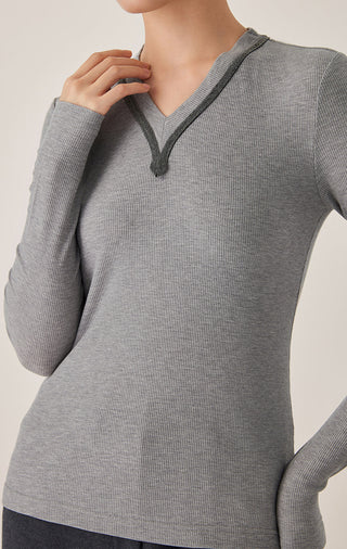 Close-up of gray V-neck ribbed knit top with dark piping