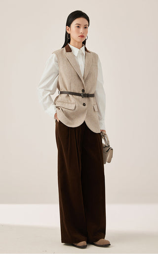 Beige belted tailored vest worn with white shirt and dark trousers, button front