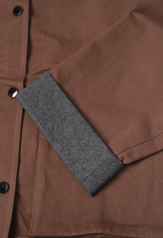 Brown jacket close-up with gray felt inner panel and button placket stitching