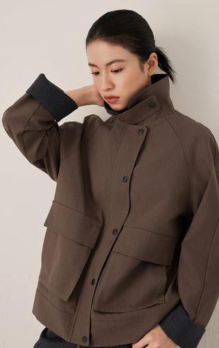 Brown stand-collar jacket close-up, button placket with flap pockets and contrast cuffs