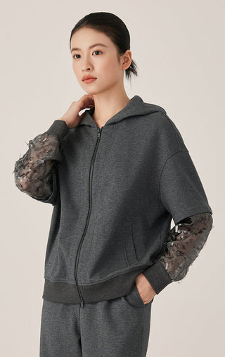 Dark gray cotton zip hooded jacket with sheer patterned mesh cuffs, model front view