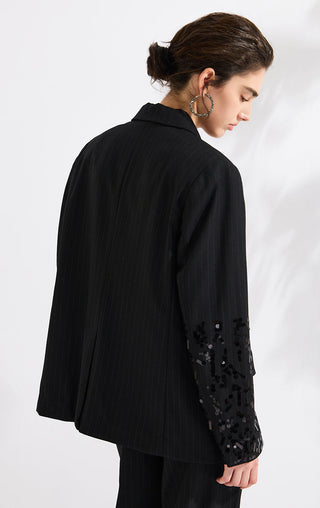 Black pinstripe blazer with sequined sleeve panel, side profile