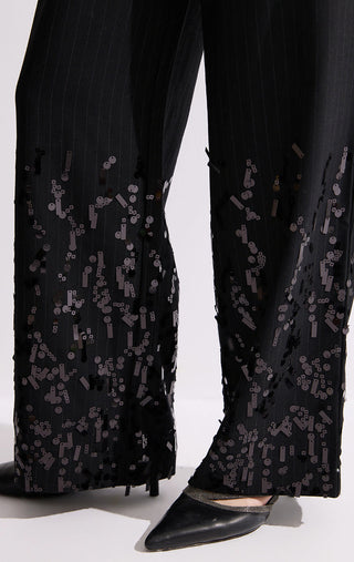 Close-up of black sequin-embroidered sheer hem panels on pinstripe wide-leg trousers