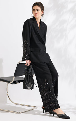 Black pinstripe wide-leg trousers with sequin embellishment along the leg hems
