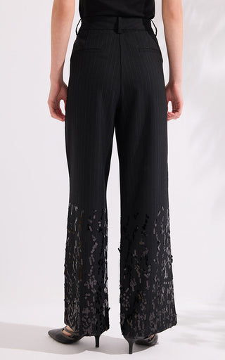 Back view of black pinstripe wide-leg trousers with sequined hem overlay