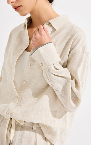 Beige linen point-collar button-up shirt with buttoned cuffs, close-up