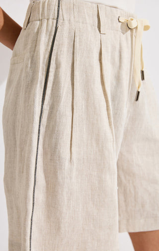 Beige linen shorts close-up: drawstring waist and side silver beaded chain detail