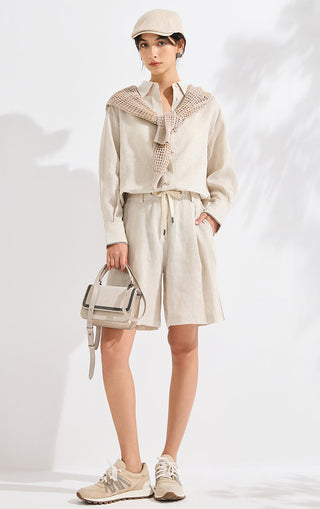 Beige linen wide-leg shorts with drawstring waist and pleated front, mid-thigh length