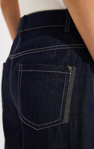 Close-up of denim shorts back pocket with topstitching and zipper pull