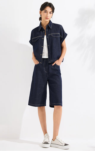 Denim blue cotton-linen blend denim shorts on model, wide straight legs and patch pockets