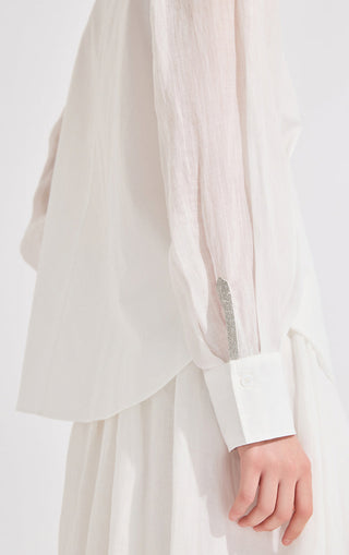 Close-up of white long-sleeve shirt cuff with silver beaded trim