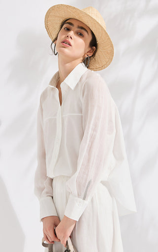 Side view of white long-sleeve button shirt with silver beaded cuff detail