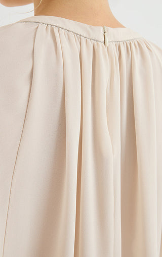 Chiffon blouse close-up: pleated fabric at yoke seam and gathered neckline band