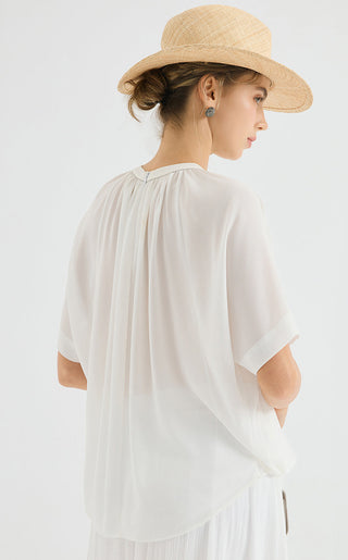 White chiffon blouse back/side view with pleated yoke and flowing short sleeves