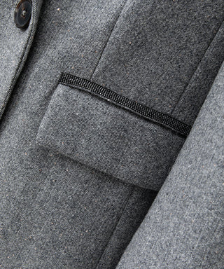 Grey blazer chest pocket and flap detail with textured fabric and dark trim