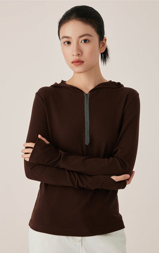 Brown half-zip hooded top with beaded zipper detail and fitted long sleeves