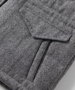 Grey wool-blend down vest close-up: textured weave, pocket flap, and zip edge