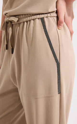 Khaki wide-leg pants close-up: elastic waist, drawstring ties, side pocket panel