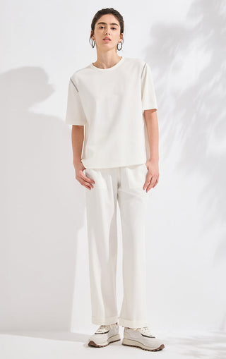 Ivory white wide-leg lounge pants with elastic drawstring waist and tapered cuffs