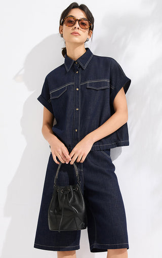 Ink blue cropped denim shirt with button front and chest pockets, worn with matching bottoms