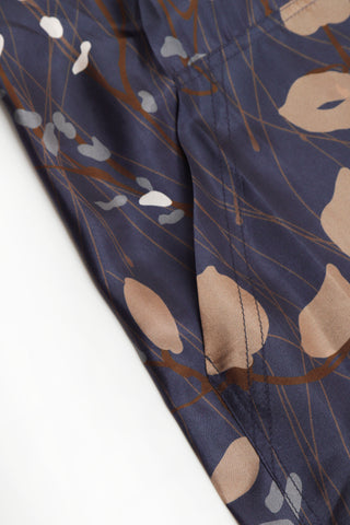 Close-up of navy printed fabric with leaf shapes and fine line pattern.