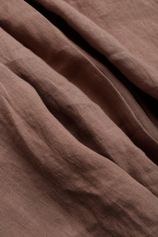 Close-up of brown linen folds showing fine woven texture