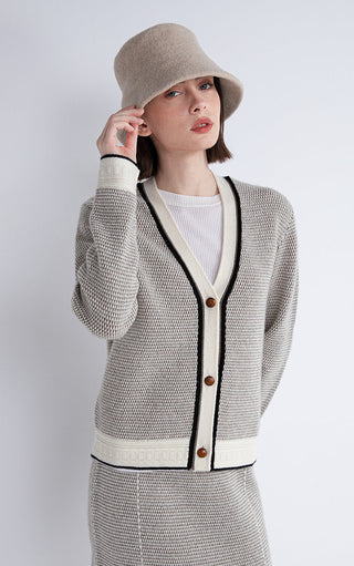 Gray cardigan with V-neck, black trim, brown buttons, and cream hem band