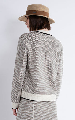 Back view of gray textured cardigan with black trim and cream waistband