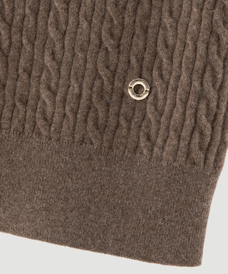 Brown cashmere turtleneck knit close-up with metal ring logo and ribbed hem