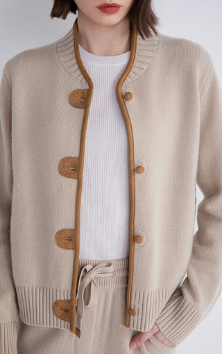 Camel wool knit cardigan close-up: contrast trim and round button placket, ribbed hem
