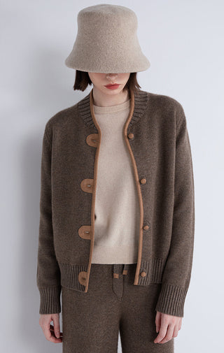 Dark camel knit cardigan close-up with contrast trim and round buttons