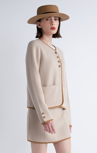 Camel short jacket with contrast border, gold-toned buttons, and side pockets