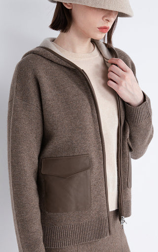 Dark camel hooded jacket close-up: zip front and sheepskin-look pocket panel on chest