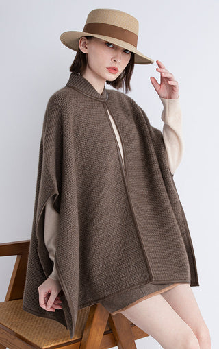 Dark brown cape with zip front and shearling-trim hem edge, angled shoulder drape