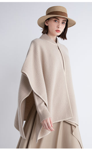 Beige cape with draped sleeves, zip front, ribbed collar, and shearling trim