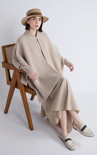 Beige wool-cashmere cape with zip front and shearling-trim hem, relaxed poncho fit